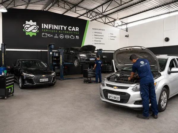 Interior da oficina Infinity Car com elevadores e carros em manutenção